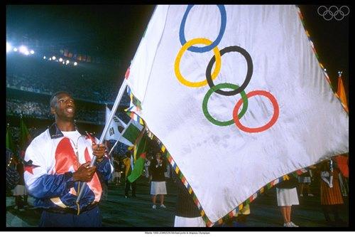 Michael Johnson carrega a bandeira olímpica durante a última edição dos Jogos Olímpicos sediada pelos EUA: Atlanta 1996 / Foto: Divulgação / COI