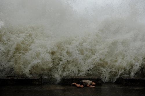 Pessoa se protege das fortes ondas do Mar Negro, em Sochi; imagem surpreende / Foto: Mikhail Mordasov