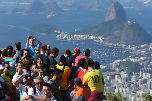 Turistas tiram fotos no Cristo Redentor, no Corcovado / Foto: Julian Finney / Getty Images